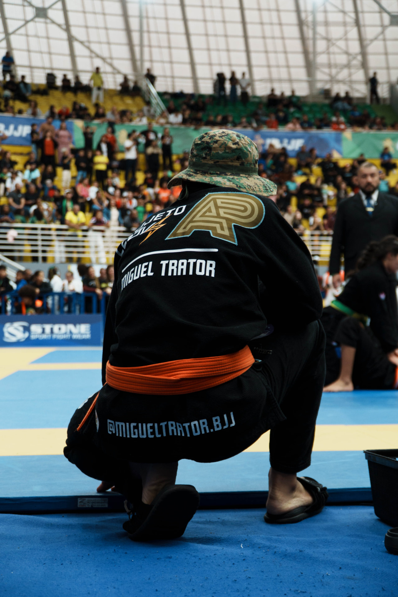 Miguel Trator ajoelhado à beira do tatame antes da luta